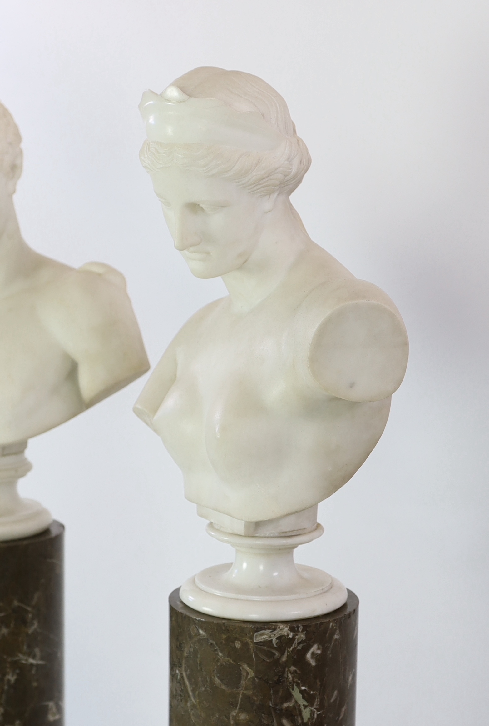 After the Antique. A pair of 19th century white marble busts of Apollo and Diana, Busts 57cm high, columns 121.5cm high
